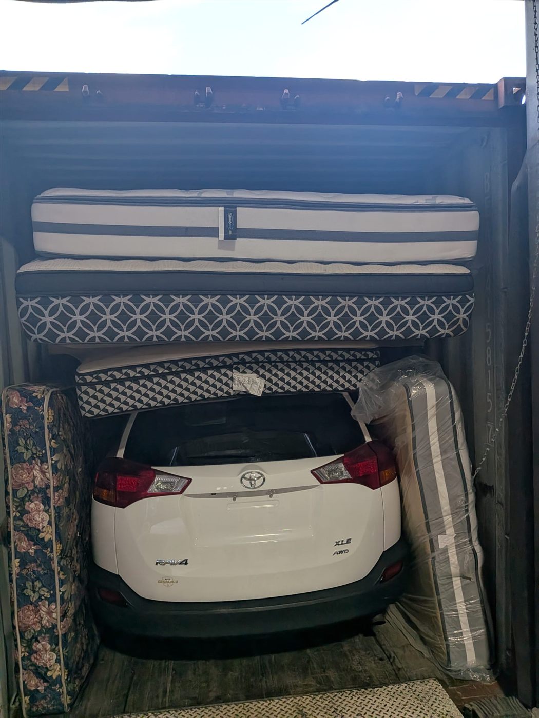 Toyota RAV4 chargé dans un conteneur maritime avec des marchandises, prêt pour l'expédition vers Conakry en Guinée